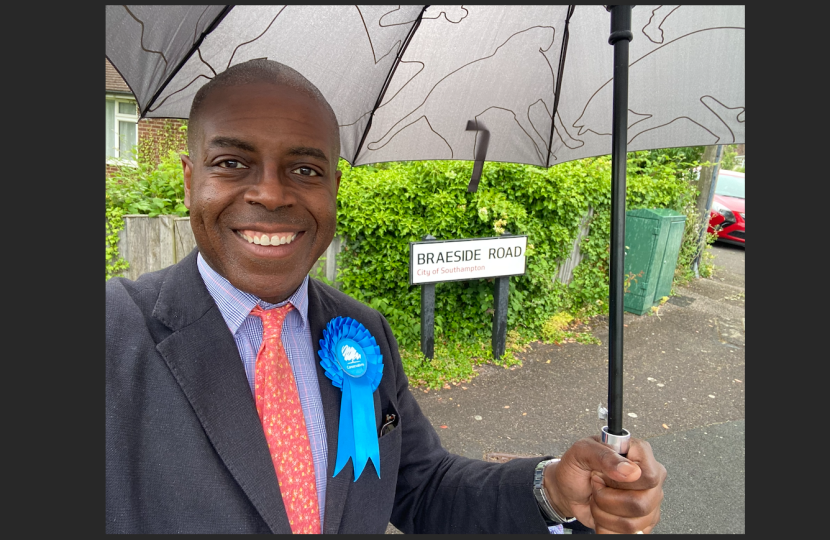 Sidney Yankson listening to residents in the rain about the poor roads in Peartree