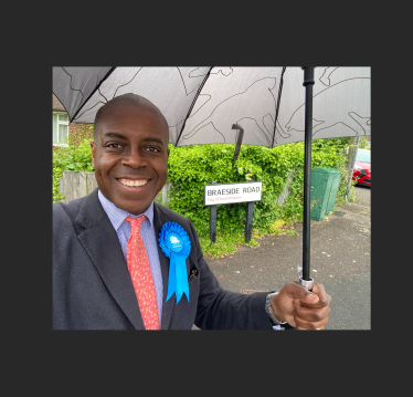 Sidney Yankson listening to residents in the rain about the poor roads in Peartree